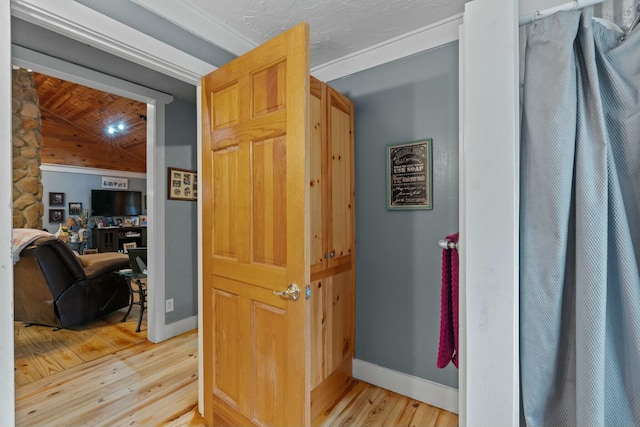 hall featuring lofted ceiling and light wood-type flooring