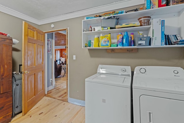 clothes washing area featuring light hardwood / wood-style floors, separate washer and dryer, and ornamental molding