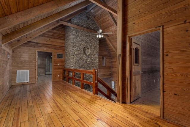 interior space featuring wooden walls, high vaulted ceiling, and wood-type flooring