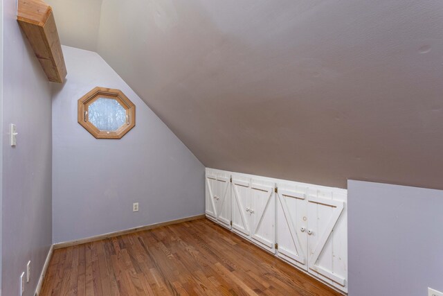 bonus room with lofted ceiling and light hardwood / wood-style flooring