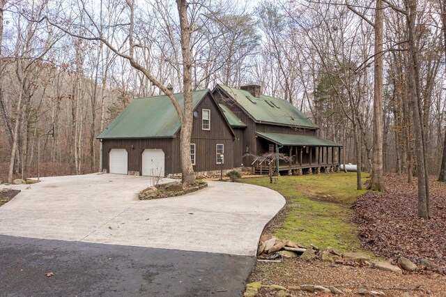 view of front facade with a front yard, a garage, and a wooden deck