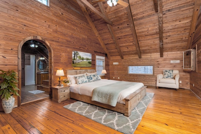 unfurnished bedroom featuring wood ceiling, wooden walls, beam ceiling, high vaulted ceiling, and light hardwood / wood-style flooring