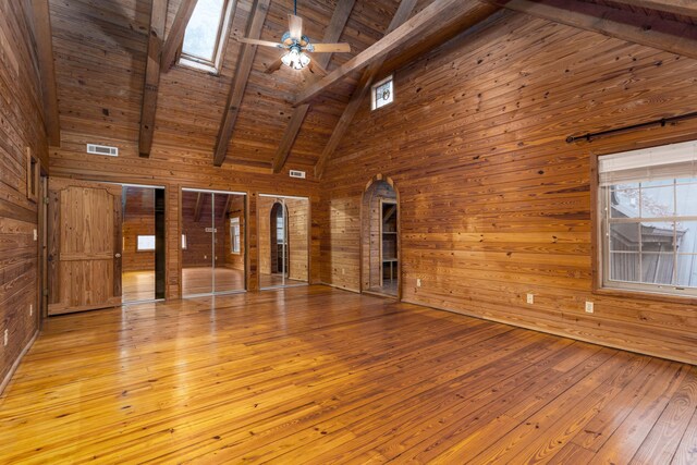 interior space featuring ceiling fan, high vaulted ceiling, wooden ceiling, beamed ceiling, and wood walls