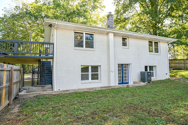 rear view of property with a lawn and cooling unit