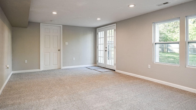 carpeted spare room featuring french doors