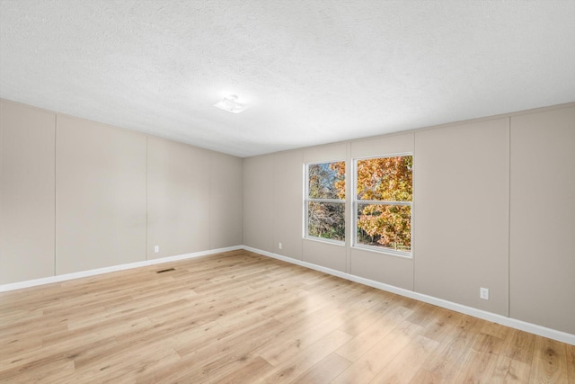 empty room featuring light hardwood / wood-style flooring and a textured ceiling