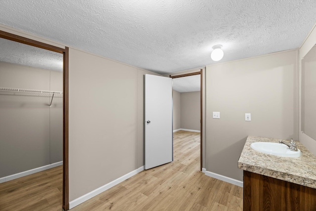 bathroom with vanity, wood-type flooring, and a textured ceiling