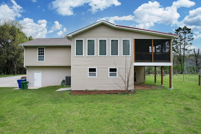 rear view of house featuring a yard, central AC, and a sunroom