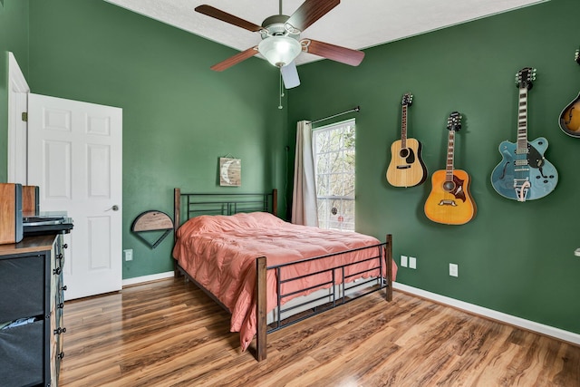 bedroom with baseboards, a ceiling fan, and wood finished floors