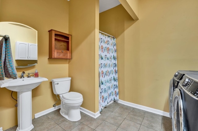 full bathroom featuring baseboards, tile patterned floors, toilet, washer and clothes dryer, and a sink