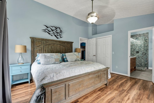 bedroom featuring a closet, baseboards, a ceiling fan, connected bathroom, and wood finished floors