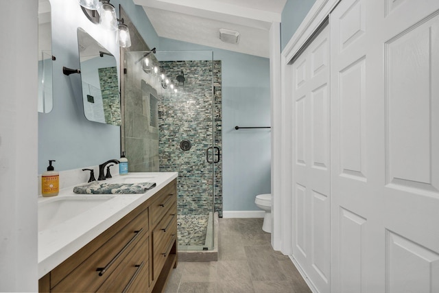 bathroom with toilet, double vanity, a sink, and a stall shower