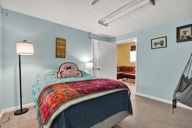 bedroom with a textured ceiling, carpet flooring, and baseboards