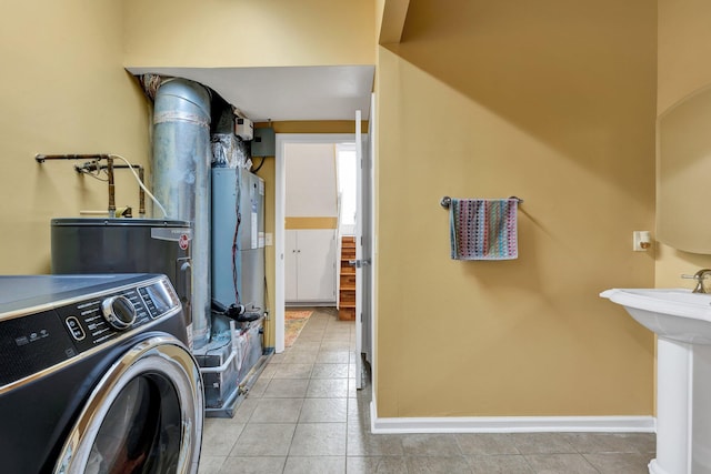 laundry area with washer / clothes dryer, laundry area, baseboards, and tile patterned flooring