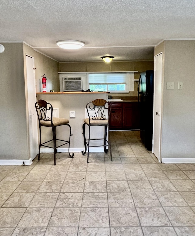 201 S Facy St, Rockwood, TN 37854 - kitchen with a kitchen breakfast bar, a sink, crown molding, a textured ceiling, and baseboards