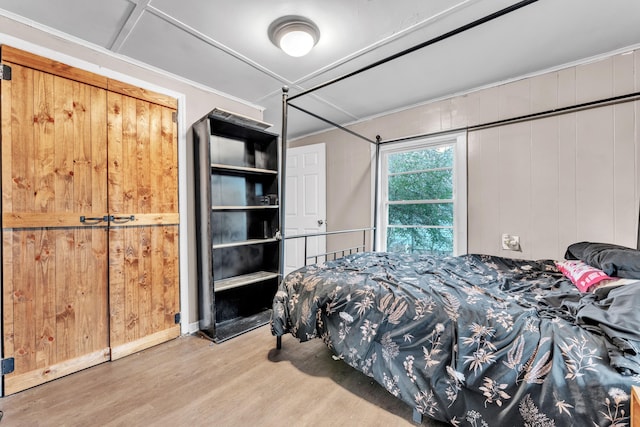 bedroom with wooden walls and light hardwood / wood-style flooring