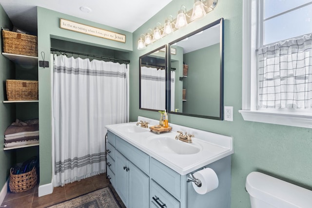 full bathroom featuring toilet, a wealth of natural light, and a sink