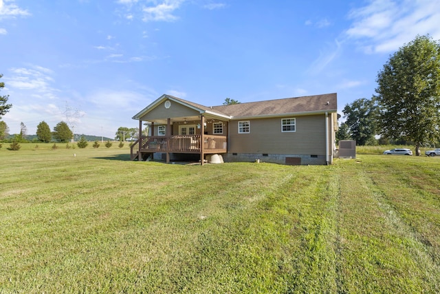 rear view of house featuring a deck, a yard, and crawl space