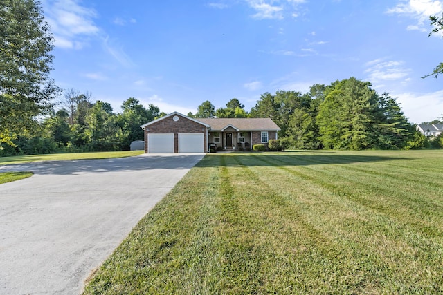 single story home featuring a front yard, concrete driveway, brick siding, and an attached garage