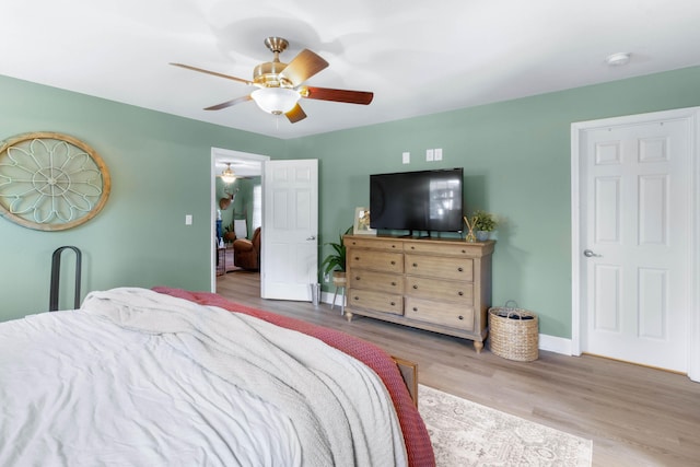 bedroom with ceiling fan, baseboards, and wood finished floors