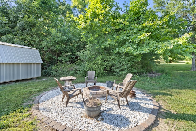 view of patio featuring an outdoor structure, a fire pit, and a storage unit