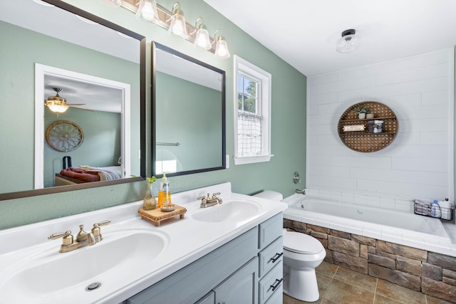 full bathroom with toilet, ensuite bath, double vanity, and a sink