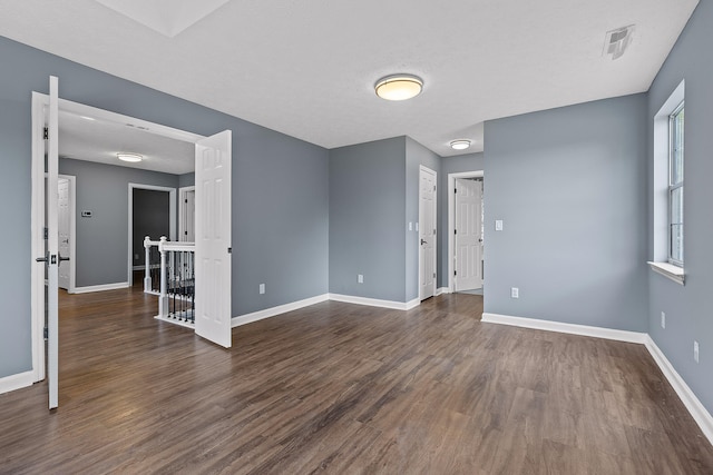 spare room featuring dark hardwood / wood-style flooring, a healthy amount of sunlight, and a textured ceiling