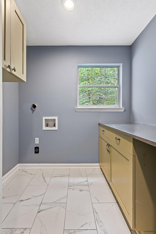 clothes washing area featuring cabinets, hookup for a washing machine, a textured ceiling, and electric dryer hookup