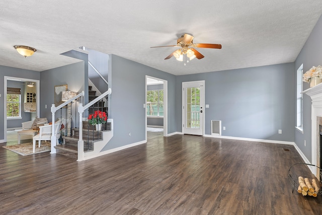 unfurnished living room featuring a textured ceiling, dark hardwood / wood-style floors, and ceiling fan