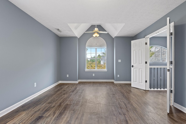 unfurnished room featuring dark hardwood / wood-style floors, a wealth of natural light, and vaulted ceiling