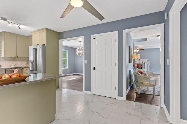 kitchen with stainless steel appliances, an inviting chandelier, green cabinets, light hardwood / wood-style floors, and decorative backsplash