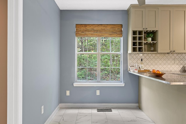 kitchen featuring decorative backsplash and a healthy amount of sunlight