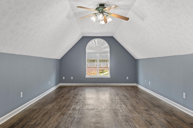 additional living space featuring a textured ceiling, dark hardwood / wood-style floors, ceiling fan, and lofted ceiling