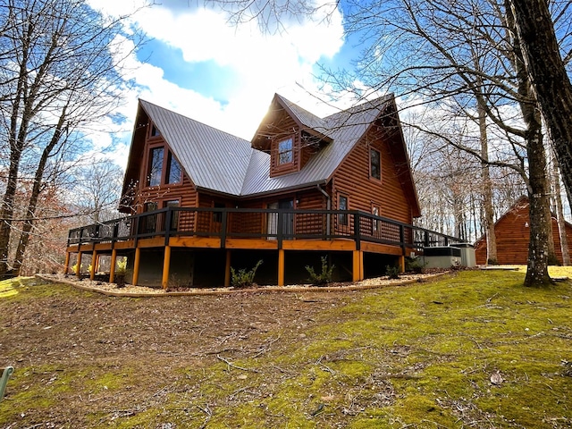 rear view of house featuring a deck and a yard