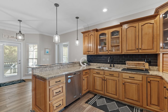 kitchen featuring brown cabinetry, dishwasher, light wood-style flooring, a peninsula, and a sink