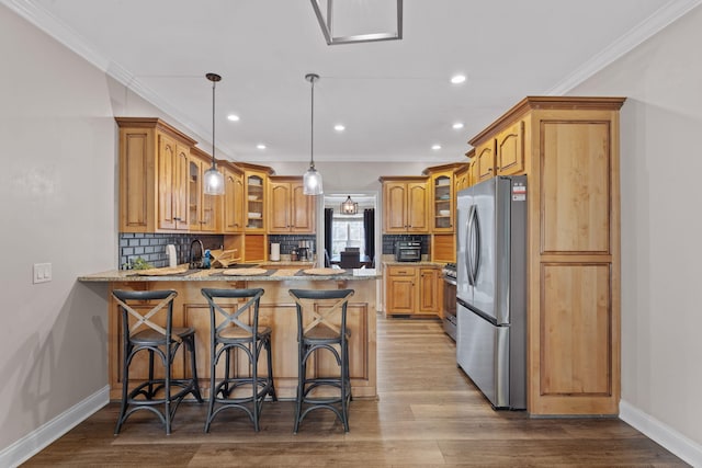kitchen featuring a peninsula, glass insert cabinets, range, and freestanding refrigerator