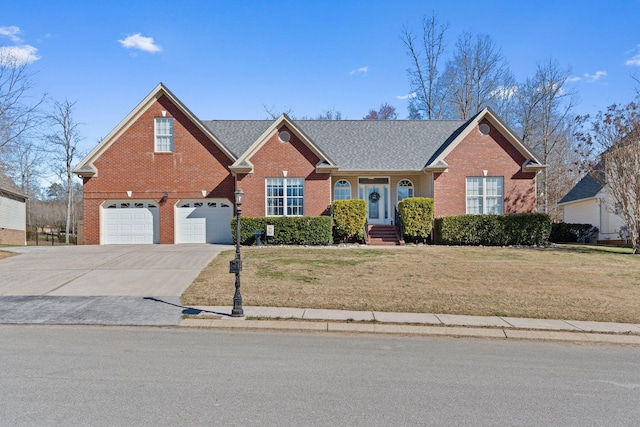 view of front of house featuring a garage, a front yard, concrete driveway, and brick siding