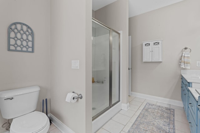 full bathroom featuring toilet, vanity, baseboards, tile patterned floors, and a stall shower