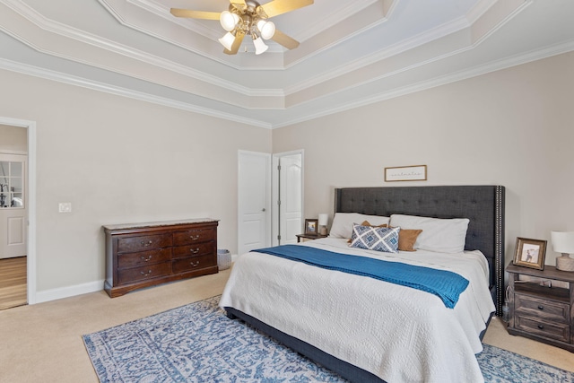 carpeted bedroom with ornamental molding, a raised ceiling, a ceiling fan, and baseboards