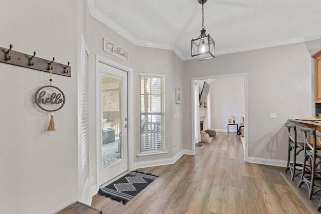 doorway to outside with baseboards, crown molding, and wood finished floors