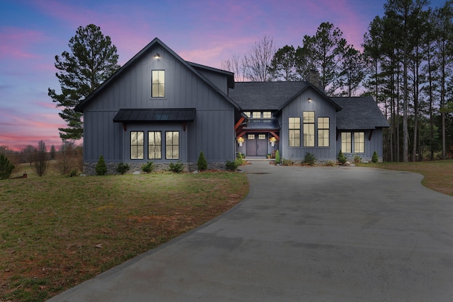 modern farmhouse with metal roof, a shingled roof, driveway, a standing seam roof, and a front yard