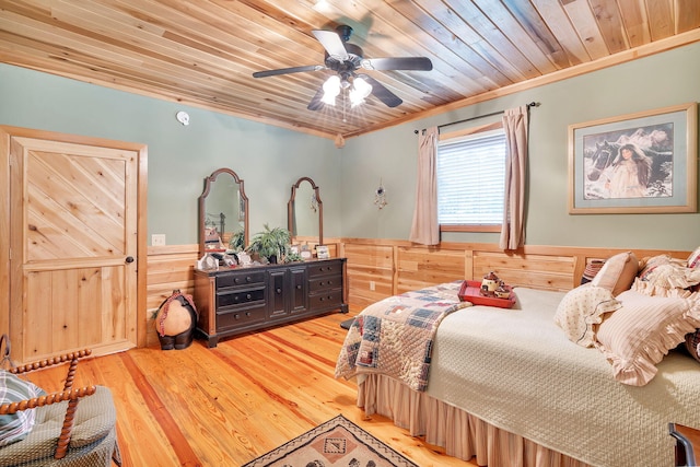 bedroom with wood ceiling, ceiling fan, crown molding, hardwood / wood-style floors, and wood walls