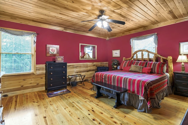 bedroom with ceiling fan, crown molding, wood walls, wood ceiling, and hardwood / wood-style flooring