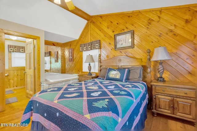 bedroom with wood-type flooring, vaulted ceiling with beams, ceiling fan, and wooden walls