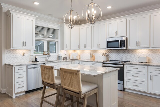 5013 Solar Ln NW, Cleveland, TN 37312 - kitchen with appliances with stainless steel finishes, a kitchen bar, white cabinets, tasteful backsplash, and crown molding
