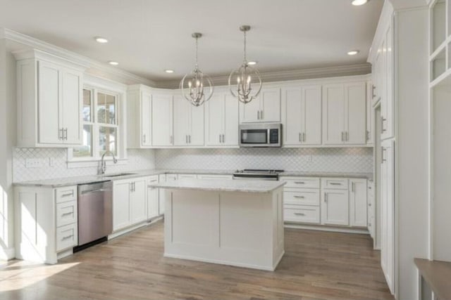 5013 Solar Ln NW, Cleveland, TN 37312 - kitchen with appliances with stainless steel finishes, a sink, a chandelier, white cabinets, and crown molding