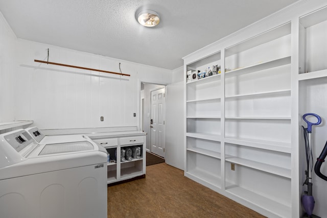 laundry area featuring a textured ceiling, dark carpet, and washing machine and clothes dryer