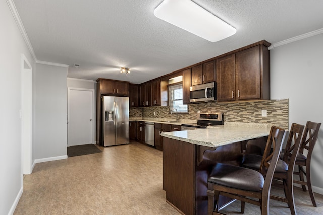 kitchen with dark brown cabinetry, appliances with stainless steel finishes, sink, backsplash, and kitchen peninsula