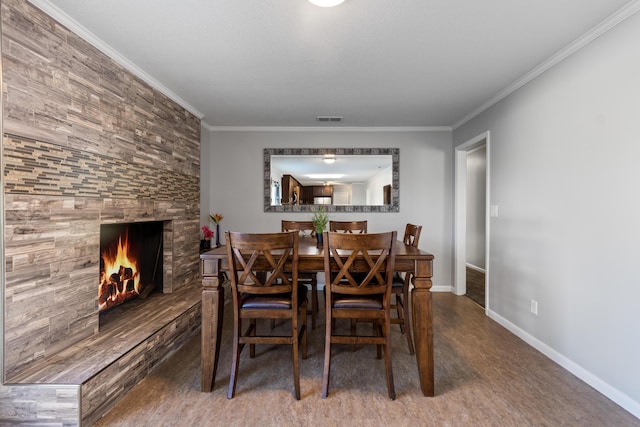 dining space with crown molding, a fireplace, and hardwood / wood-style floors