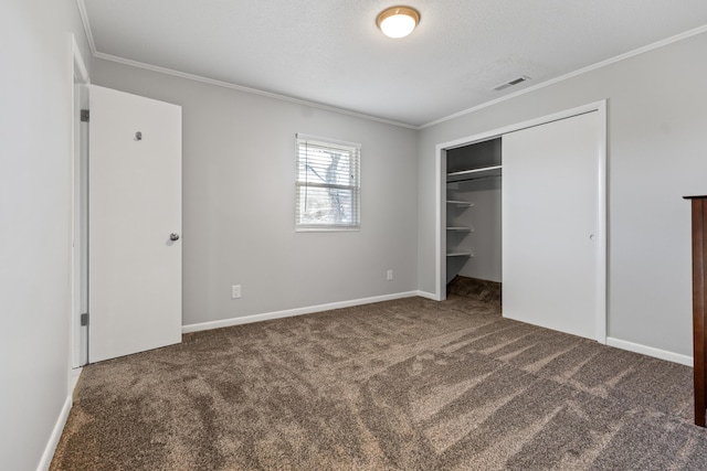 unfurnished bedroom with a closet, ornamental molding, and dark carpet